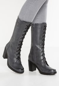 Tmavě šedé kozačky do výše kolen se šněrováním a bočním zipem, texturovaný syntetický materiál, blokový podpatek a gumová podrážka pro trakci.