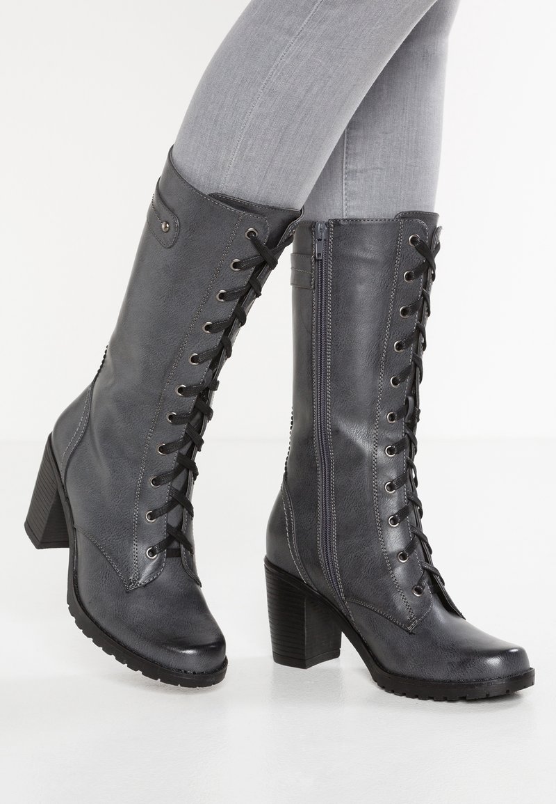Tmavě šedé kozačky do výše kolen se šněrováním a bočním zipem, texturovaný syntetický materiál, blokový podpatek a gumová podrážka pro trakci.