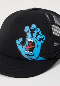 Chapéu preto com laterais em malha apresentando um gráfico de uma mão gritando azul na frente, incluindo uma língua vermelha e detalhes de texto "Santa Cruz".