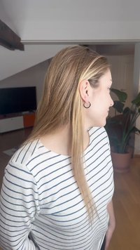 Top cu mânecă lungă în dungi albe și albastre, cu decolteu rotund. Cercei negri de tip cerc și păr drept, castaniu deschis. Cadru interior.