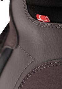 Graue Lederschuhe mit strukturiertem Finish, kontrastierenden schwarzen Akzenten und einem sichtbaren roten Etikett auf der Innenseite, mit detaillierter Naht.