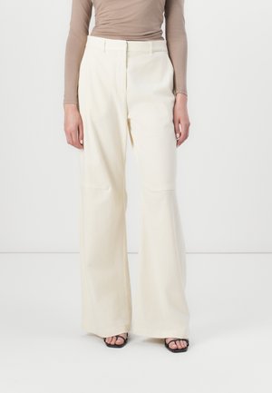 Pantaloni a gamba larga in un morbido color crema, realizzati in tessuto leggero. Presentano una vita alta, tasche frontali e una finitura pulita.