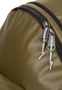 Mochila verde oliva con un material texturizado y resistente al agua, con cremalleras plateadas dobles y acentos de tela negra.