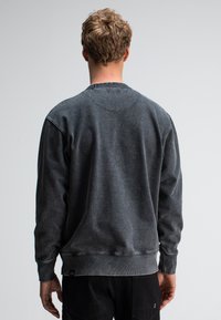 Grijze fleece sweatshirt met een ronde hals, textuurstof en geribbelde manchetten. Kenmerkt zich door een klein logo-label aan de onderzoom.