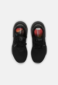 Scarpe sportive nere con tomaia in maglia strutturata, lacci e colletto imbottito. Suola in gomma e plantari colorati visibili.