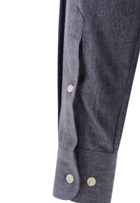 Ärmel eines blauen Fischgrätenhemdes mit zwei hellen Knöpfen und einer Tasche am Oberarm, mit einer strukturierten Stoffoberfläche.