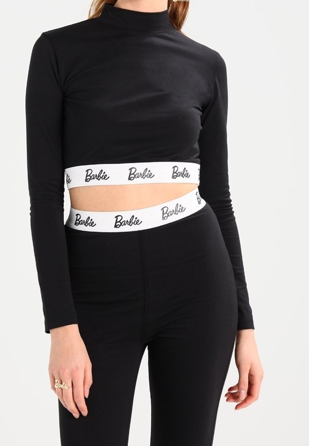 Svart långärmad crop-top med hög halsringning, med ett vitt midjeband med "Barbie"-logotyp. Mjuk, elastisk tyg. Figurformad design.