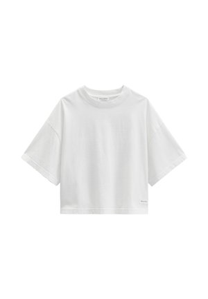 T-shirt court à manches courtes blanc avec un col rond et une petite étiquette de marque près de l'ourlet inférieur.