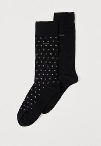 Fekete zoknik, az egyik egyszínű, a másik apró fehér és szürke téglalapokból álló mintával, márkás logóval. Puha, rugalmas anyag.