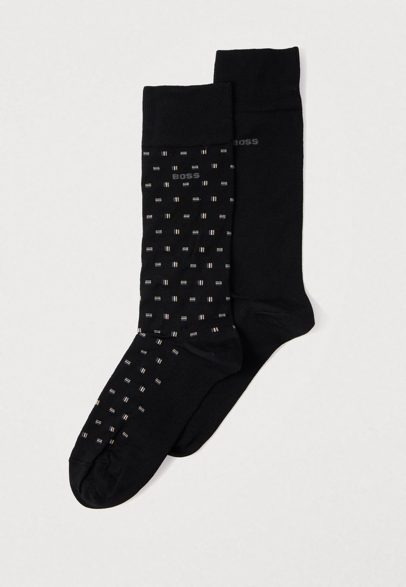 Fekete zoknik, az egyik egyszínű, a másik apró fehér és szürke téglalapokból álló mintával, márkás logóval. Puha, rugalmas anyag.