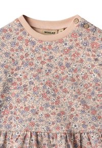Blumenmusterkleid mit hellrotem Grund, das kleine lila, rote und weiße Blumen zeigt. Gerippter Kragen mit zwei Knopfakkzenten. Rüschenabschluss.