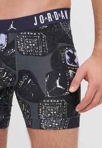 Fekete boxer alsónadrág absztrakt mintával, rugalmas derékpánttal "JOAIRDAN" felirattal és testhezálló dizájnnal, rugalmas anyagból készült.