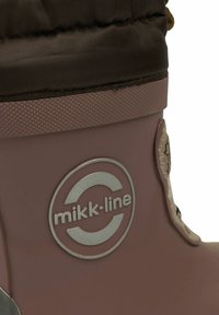 Bota de goma rosa con parte superior de tela marrón texturizada, logo plateado y herrajes a juego. Cuenta con un cordón para ajuste.