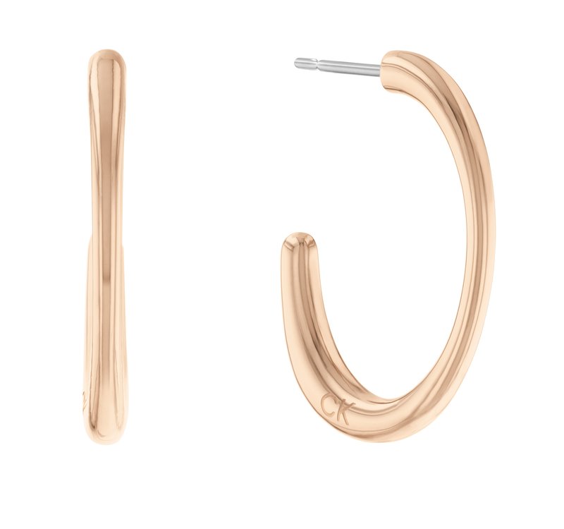 Orecchini a cerchio in tono oro con un design liscio e arrotondato, arricchiti da una leggera incassatura. Presentano un perno in metallo per una chiusura sicura.
