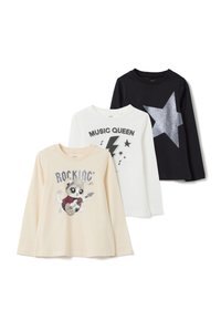 Drie longsleeve T-shirts: één crèmekleurig met een kattenafbeelding, één wit met een bliksemschicht, één zwart met een zilveren ster. Gemaakt van katoen.