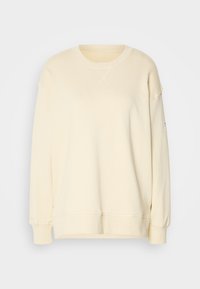 Sweat-shirt à manches longues de couleur crème avec col rond, poignets et ourlet côtelés, présenté sur un fond uni gris clair.