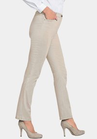 Beige slim-fit broek van rekbare stof, met een soepele textuur, voorzakken en gecombineerd met grijze hoge hakken.