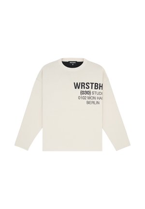Krämfärgad långärmad sweatshirt med texten "WRSTBH (030) STUDIO 0102 MON HAH BERLIN" i svart, rund halsringning och avslappnad passform.