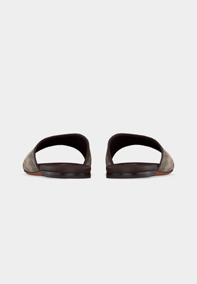 Paire de chaussures plates à enfiler, à talon ouvert, avec une tige en tissu imprimé et des semelles marron foncé, vues de l'arrière sur un fond blanc.