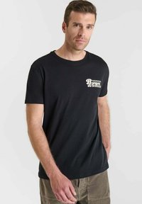 Camiseta negra de manga corta con estampado en el pecho delantero en blanco, hecha de algodón con una textura suave y un corte relajado.