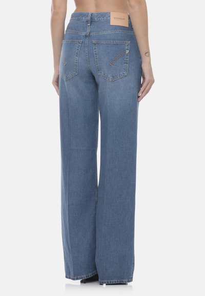 Jean denim bleu à jambes larges avec poches arrière et une étiquette de marque sur la ceinture, porté par une personne montrée de la taille vers le bas.