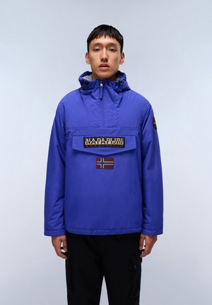 Blå anorak jakke med en frontlomme med et fremtrædende logo og et norsk flag-patch; justerbar hætte og elastiske manchetter.