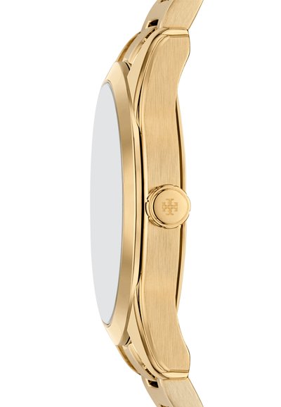 Reloj de metal dorado con un acabado suave y pulido, caja redondeada y una correa texturizada. Presenta un detalle de corona circular en el lado.