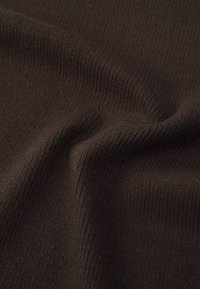 Tejido marrón acanalado con una textura suave, que presenta líneas verticales y una superficie lisa, drapeado en suaves ondas.