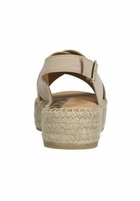 Sandale espadrille beige avec une plateforme en jute tissé, une sangle ajustable et un dessus en daim lisse. Comprend une boucle arrière pour un maintien sécurisé.