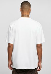 Kortærmet T-shirt med rund hals i hvid bomuld, med et enkelt design og en afslappet pasform. Bagsiden har minimal detaljer.
