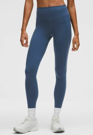 Blå højtaljede leggings med et glat, strækbart materiale. Designet har en tætsiddende form og sømløs konstruktion, velegnet til aktivt tøj.