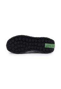 Suela de zapato de goma negra con superficie texturizada que presenta un patrón de cruces elevadas. Detalle verde con el texto "MUNIC" en el lateral.
