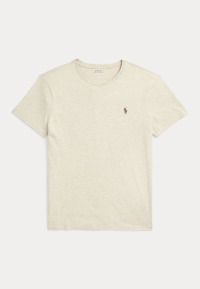 Béžové tričko s krátkym rukávom a okrúhlym výstrihom s malým hnedým logom Polo Ralph Lauren na ľavej strane hrudníka.