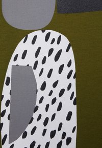 Tejido abstracto que presenta formas irregulares en verde olivo, gris y blanco con manchas negras, creando un diseño texturizado y patrones.