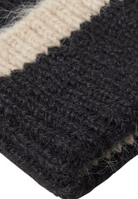 Copertura lavorata a maglia in grigio scuro e crema. Tessuto morbido e testurizzato con cuciture visibili, caratterizzato da un motivo a righe e una finitura accogliente.