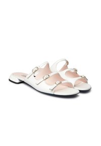 Sandali slip-on bianchi in pelle con tre cinturini stretti, dettagli dorati e tacco basso. Soletta rosa chiaro con design open-toe.