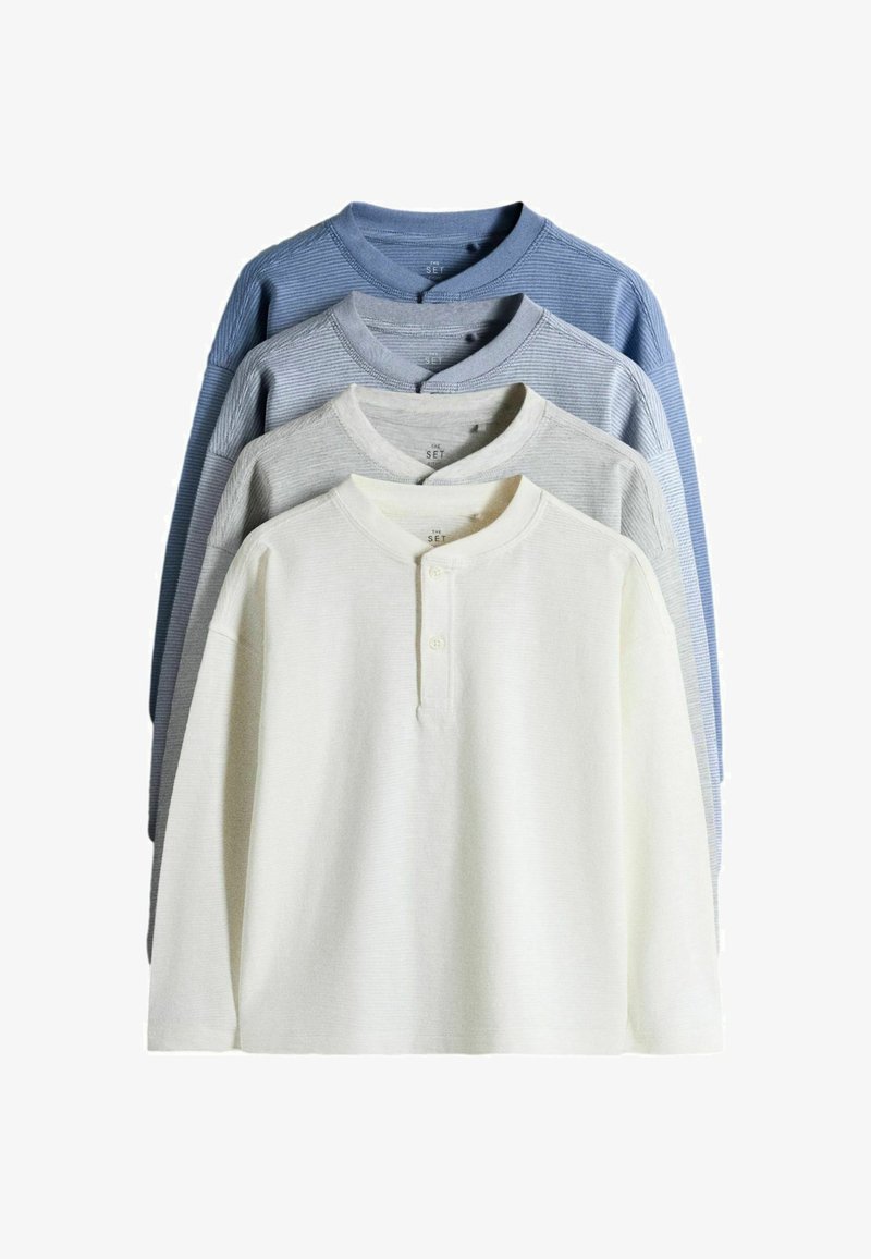 Cuatro camisetas Henley de manga larga apiladas en blanco, gris claro, gris y azul, con cuellos redondos y tapetas con dos botones.