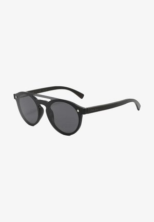 Occhiali da sole neri rotondi con lenti scure, dotati di una montatura in plastica spessa e dettagli in metallo sulle cerniere. Design minimalista con texture liscia.