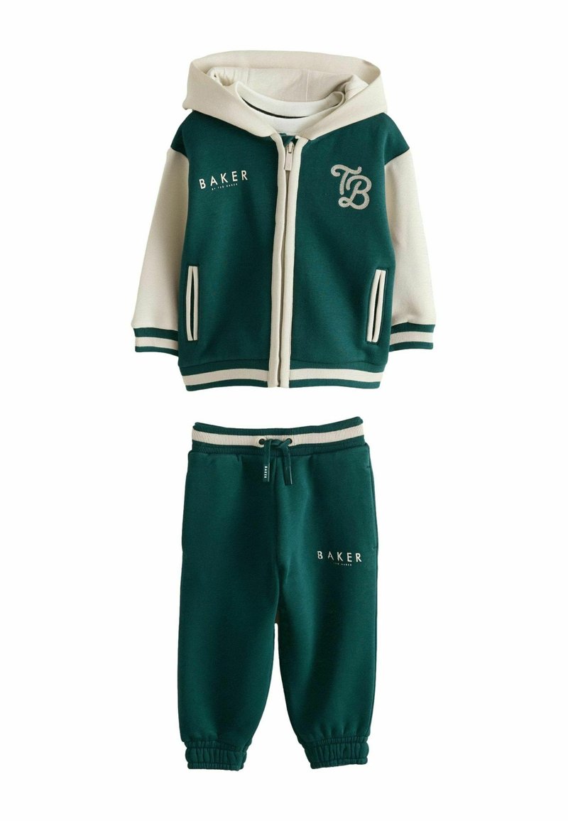 Sudadera con cremallera en verde y crema con acentos de logo y dos bolsillos laterales, combinada con pantalones de chándal verdes a juego que cuentan con un cordón y logo.