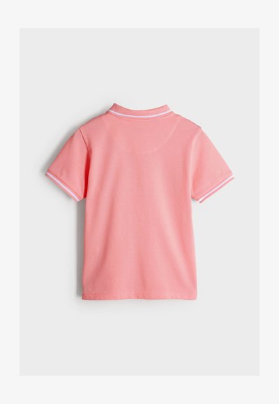 Roze poloshirt met korte mouwen, voorzien van witte biezen aan de kraag en mouwen. Gemaakt van gladde stof met een effen kleurontwerp.