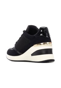 Zapatilla negra con parte superior de ante, paneles texturizados, acentos de charol brillante y un tacón cuña con una banda dorada y suela blanca.