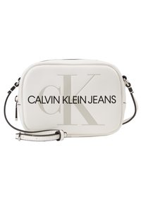 Borsa a tracolla bianca con texture liscia, caratterizzata da un grande logo "CK" in rilievo e testo "CALVIN KLEIN JEANS" in nero. Tracolla lunga inclusa.