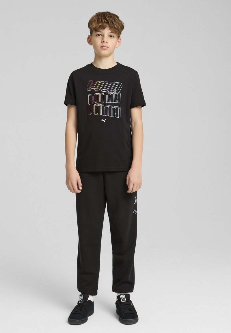 Zwarte Puma t-shirt met een meerkleurig gestapeld logo, gecombineerd met zwarte joggers en zwarte sneakers. Eenvoudig ontwerp, comfortabele pasvorm.