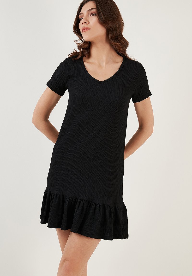Black short-sleeve dress with a V-neckline, featuring a textured fabric and a ruffled hemline. Simple, straight-cut design.