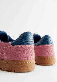 Rosa mockaskor med blå läderdetaljer, platt gummisula, vadderad krage och sydda detaljer på baksidan.