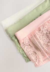 Trois morceaux de tissu : blanc, vert doux et rose clair. Le rose présente une dentelle florale le long d'un bord ; tous ont des textures lisses et des formes uniformes.