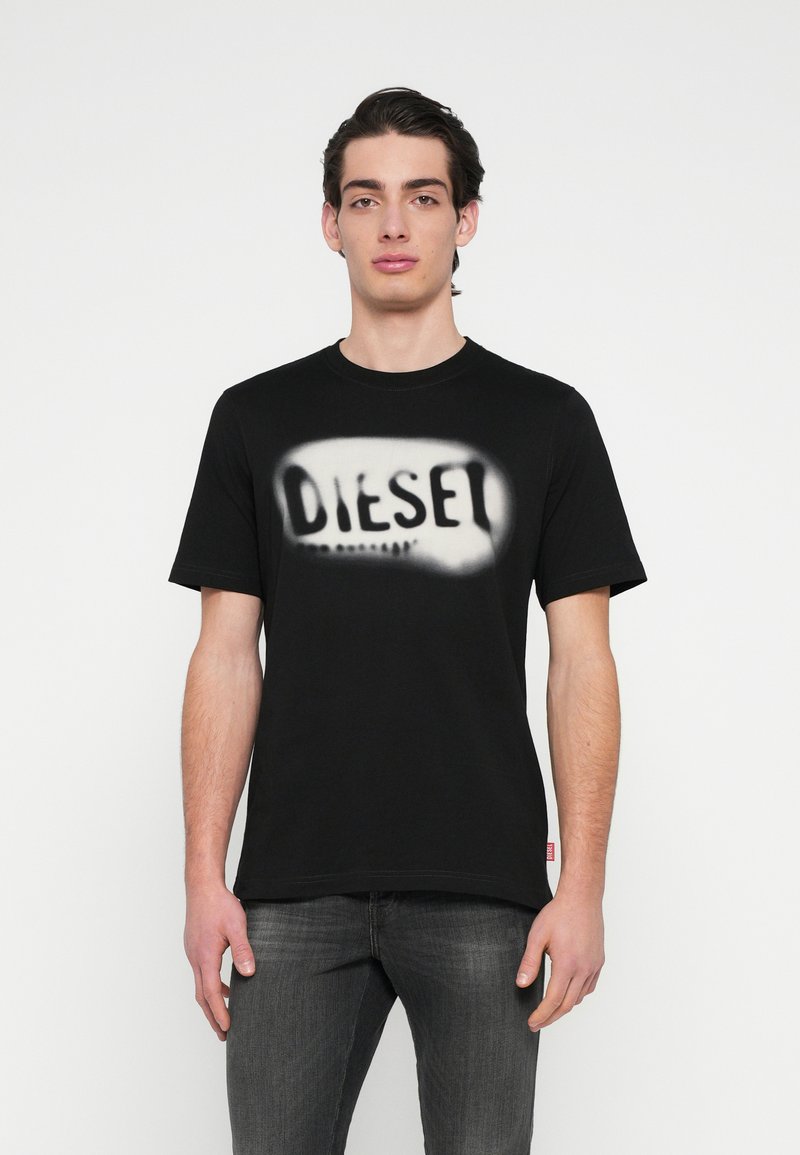 Μαύρο βαμβακερό T-shirt με ανάγλυφο, αντίθετο γραφικό της λέξης "DIESEL" στο μπροστινό μέρος. Κοντά μανίκια και στρογγυλή λαιμόκοψη.