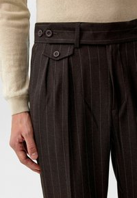 Donkerbruine gestreepte broek met plooien en duale knoopsluiting. De stof heeft een soepele textuur en een perfecte pasvorm.