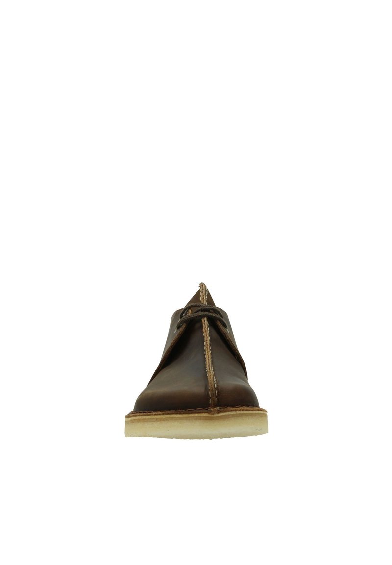 Scarpa in pelle marrone con punta arrotondata, dettagli cuciti e chiusura con lacci minimalista. La suola spessa di colore crema aggiunge un contrasto al superiore.