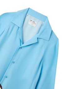 Camicia azzurra button-up con colletto a punta, texture liscia e orlo arrotondato. Presenta due bottoni frontali e dettagli di cucitura minimi.